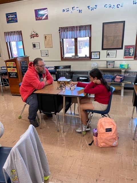 Student playing chess with coach